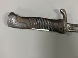an old knife that is hanging on a wall