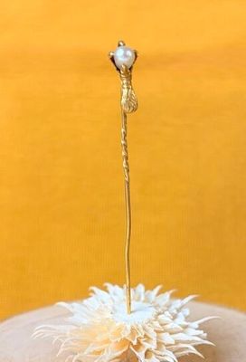 une petite fleur blanche au bout du doigt de quelqu'un
