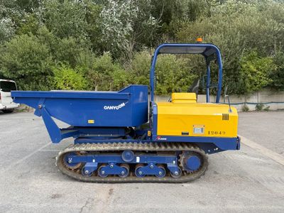 a small blue and yellow construction vehicle parked in a parking lot