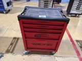 a close up of a red tool box on wheels in a warehouse