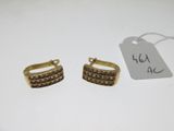 a pair of gold tone earrings with brown crystals