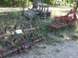 many old farm implements that are sitting in the grass
