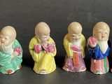 six small figurines of asian people are lined up in a row