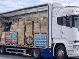 un camion avec une remorque chargée de cartons à l'arrière