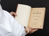quelqu'un tient un livre à la main et celui-ci est ouvert