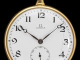 gros plan d'une montre de poche en or sur fond noir