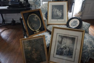 quatre photos encadrées posées sur une chaise dans un salon