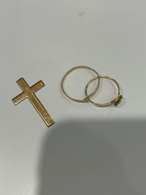 deux bagues et une croix en or posées sur une table