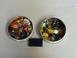 deux boîtes remplies de boutons de différentes couleurs posées sur une table