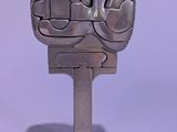 a metal sculpture of a fist on top of a stand