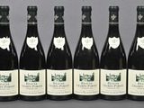six bottles of wine are lined up in a row on a table