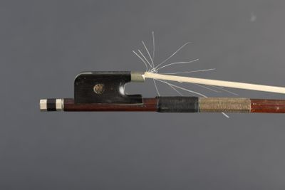a bow with a stick sticking out of it on a gray background