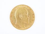 gros plan d'une pièce d'or sur une surface blanche