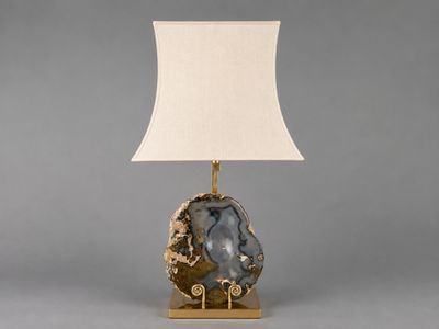 une lampe de table surmontée d'un abat-jour blanc