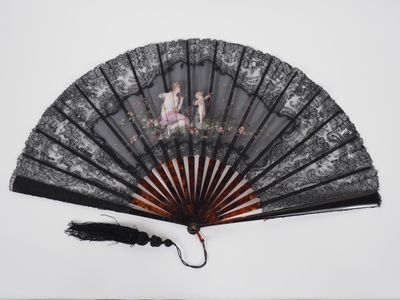 a black fan with a picture of a woman and a child on it