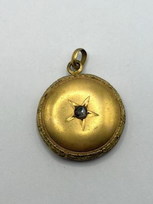 une image représentant un fer à cheveux en or orné d'un diamant noir au centre