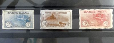 trois timbres différents exposés dans une vitrine posée sur une table