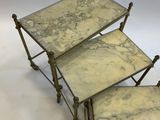 three marble topped tables with brass bases on a white background