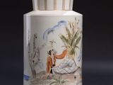 a vase with a painting on it sitting on a table