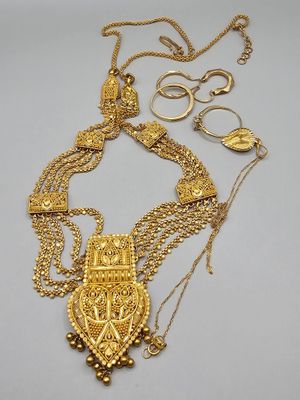 a close up of a gold necklace on a white surface