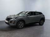 un SUV gris garé dans une pièce aux murs blancs