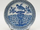 a blue and white plate with a bird on it