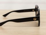 sunglasses on a wooden table with a white wall in the background