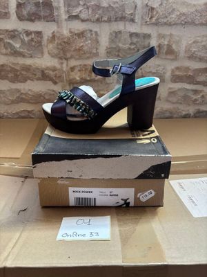 purple high heeled sandals on a cardboard box on top of a cardboard box