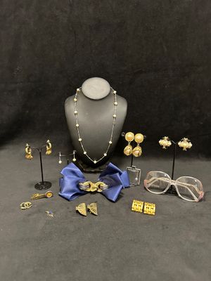 an assortment of jewelry including a necklace, glasses, and a bow tie