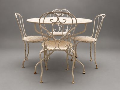 une image représentant une table blanche et quatre chaises sur un fond gris