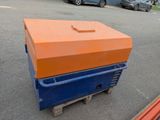 an orange and blue box sitting on a pallet in the parking lot