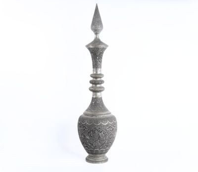 a silver vase that is sitting on a white surface