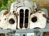 an old car that is sitting on a cart in the grass