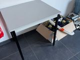 une petite table sur laquelle est posé un sac rouge