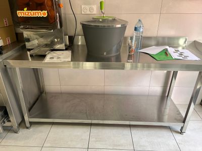 une table en acier inoxydable sur laquelle est posé un seau