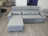 un canapé et un pouf dans un salon où est accroché un tableau au mur