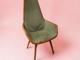 une image représentant une chaise verte sur fond rose