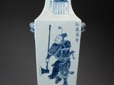 a blue and white vase with a man on it