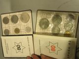 On voit deux boîtes de pièces, dont l'une est tenue dans une main
