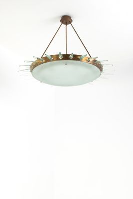 a round glass light fixture hanging from the ceiling in a white room