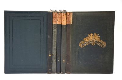 un vieux livre ouvert, dévoilant une couverture noire ornée d'un emblème doré