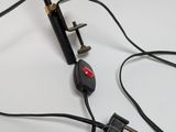 a close up of a black and red light on a white table
