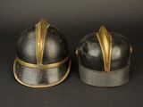 pair of helmets with gold accents on a black background