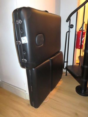 une valise noire posée par terre à côté d'un escalier