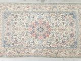 un tapis persan antique avec un motif floral sur fond blanc