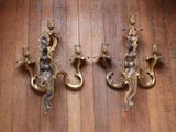 three antique brass wall sconces on a wooden floor