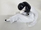 a black and white figurine of a woman sitting on a table
