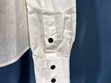 a close up of a white shirt hanging on a blue background