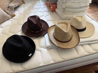 trois chapeaux posés sur un matelas, sur un lit