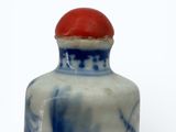 a small blue and white vase with a red lid